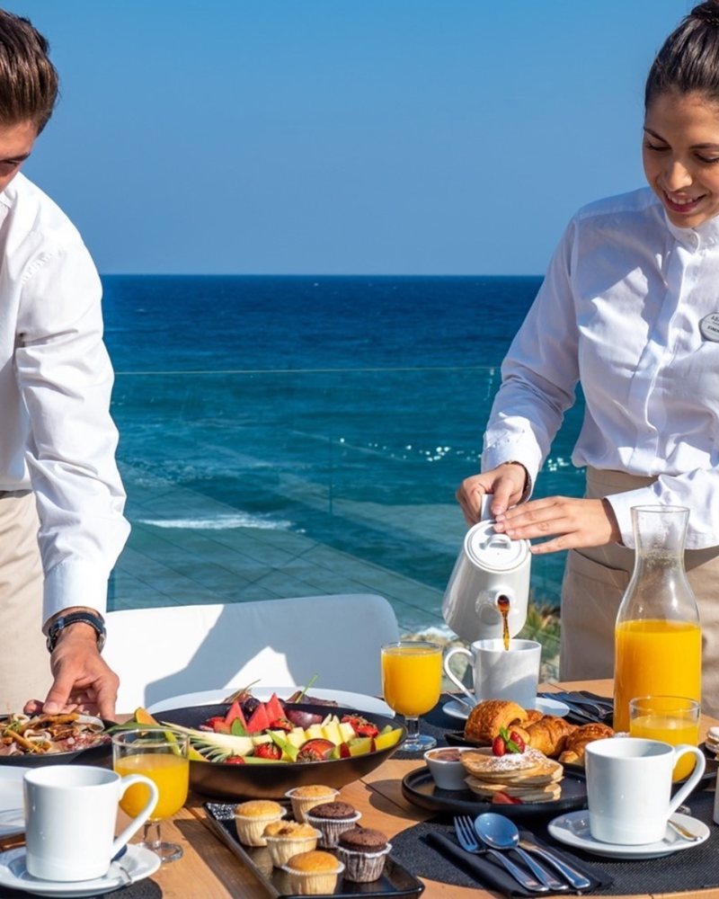 Staff setting a seaside breakfast table